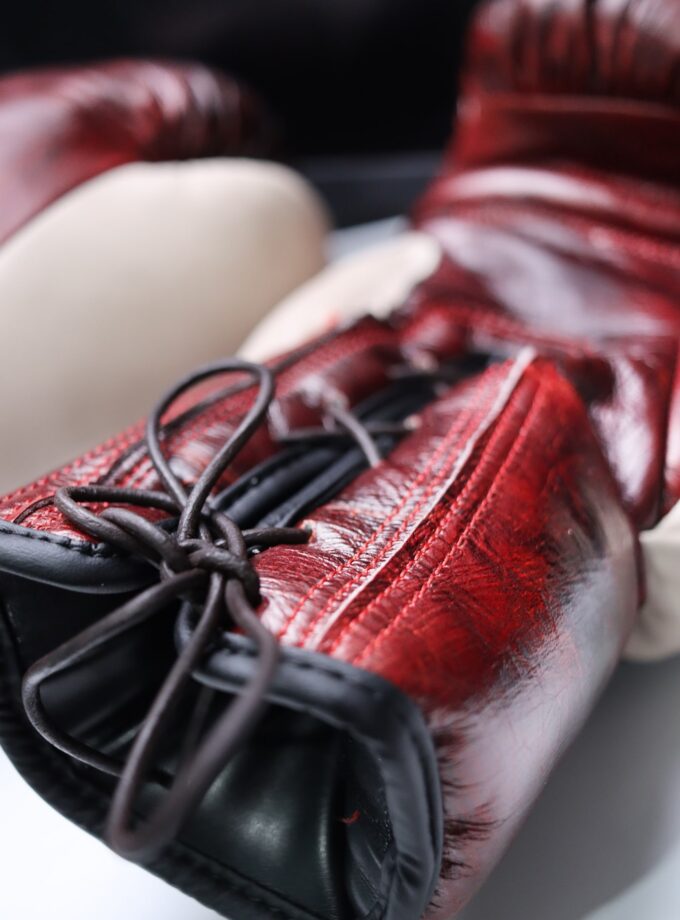 Detailed view of the lacing on the RUGA Legacy Leather Boxing Gloves in Crimson & Ivory.