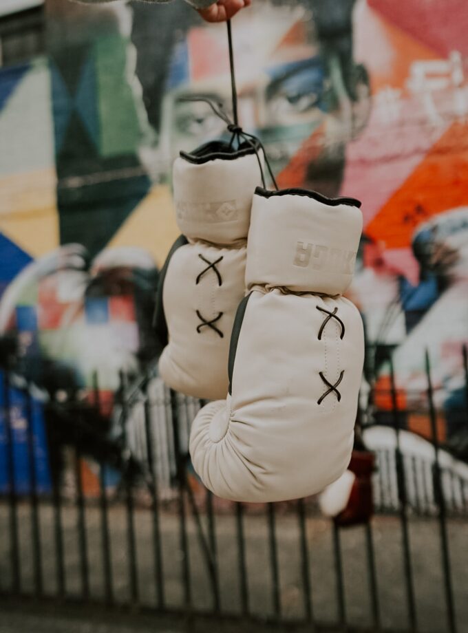 Ivory & Onyx boxing gloves in front of a vibrant graffiti wall